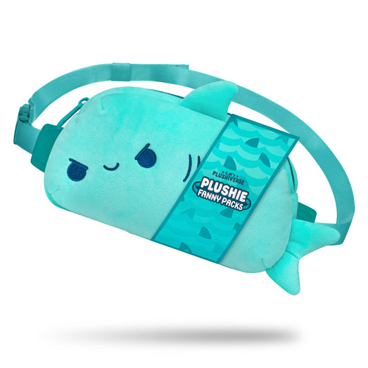 A blue, Plushiverse Jaw-some Shark Plushie Fanny Pack by TeeTurtle shaped like a fish, with a winking face and fin details, against a white background. Featuring an adjustable belt for hands-free functionality, the tag reads