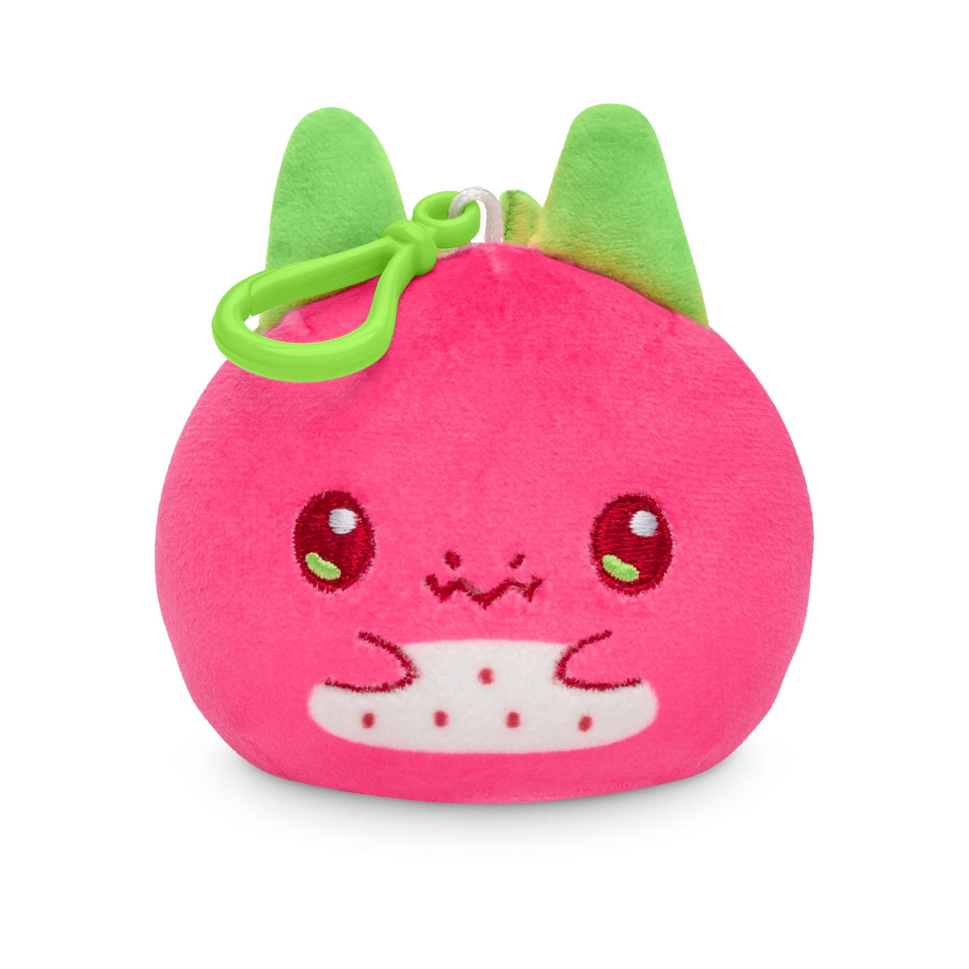 A Plushiverse Dragonfruit Reversible Plushie Keychain shaped like a pink strawberry with a cute face and green leaves on top, attached to a backpack clip by TeeTurtle.