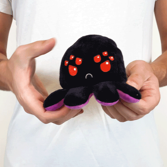 Adorable man holding a TeeTurtle Reversible Spider Plushie (Black + Purple).