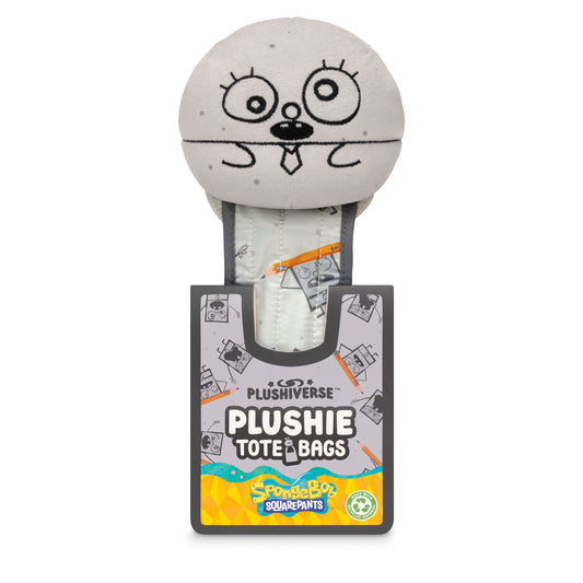A round, grey plush toy with cartoonish eyes and mouth, wearing a tie, partially tucked into a dark grey and colorful packaging labeled